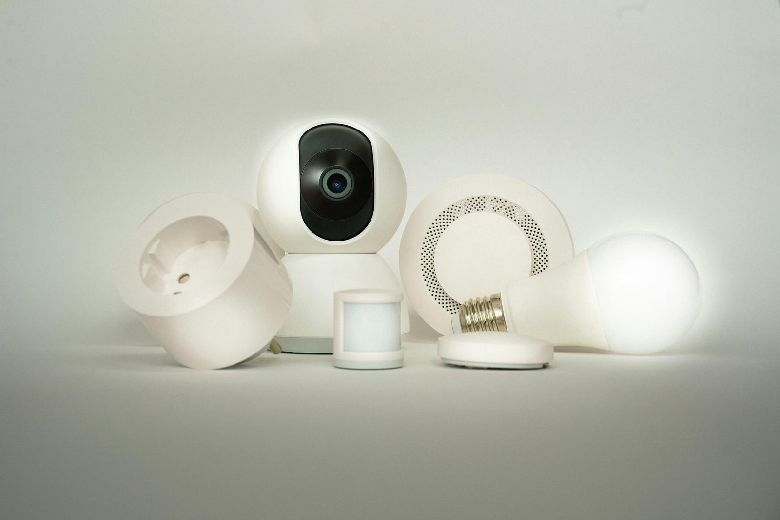 A collection of smart home devices, including a camera, light bulb, and sensors, on display.