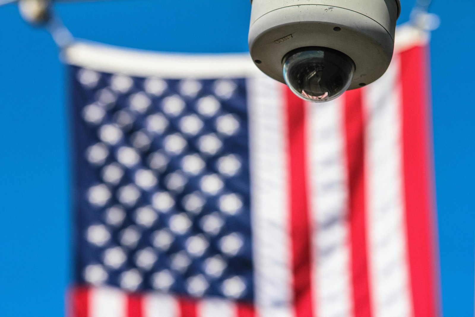 Surveillance camera focusing on security with American flag backdrop.